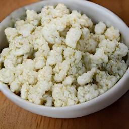 the blue cheese is in a bowl and has been crumbled into small pieces.