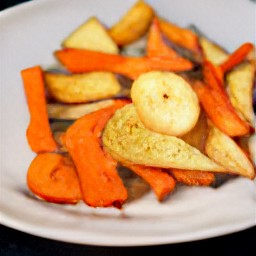 the caramelized carrots and parsnips are transferred to a serving plate.