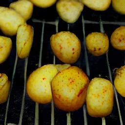 the semi-cooked potato slices are turned using tongs.
