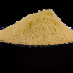 the parmesan cheese is shredded into small pieces using a grater.