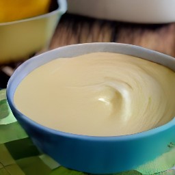 a bowl of combined butter and granulated sugar, mixed for 3 minutes with an electric mixer. there is also one egg added to the mixture, as well as vanilla extract.