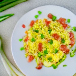 the cornstarch mixture is transferred to the skillet pan and stirred with a wooden spoon, then the egg with tomatoes is transferred to a platter.