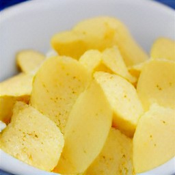 a bowl containing cracked eggs, whisked potatoes, and a wooden spoon.