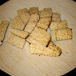 onions that are peeled and chopped, and tempeh that is cut into squares.