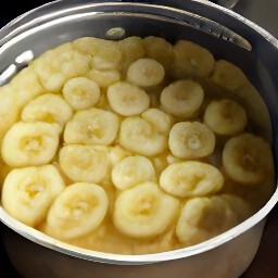 a cake tin with melted clarified butter, maple syrup, chopped walnuts, and banana slices.