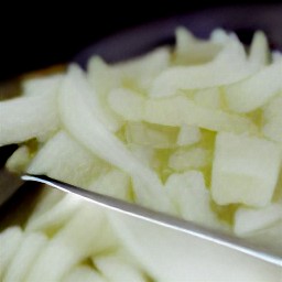 a bowl of chopped onions, green bell peppers, celery sticks, and parsley.