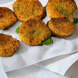 the cajun chickpea cakes are transferred to a towel paper and served on a platter.