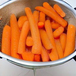 the carrots that were steamed are now in the colander and they are draining.