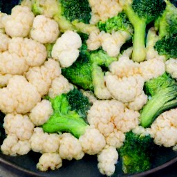 a platter of seasoned veggies with a yellow mustard sauce.