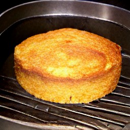 the cake pan is taken out of the oven and the apple cornbread is transferred to a platter.