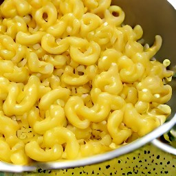 the macaroni pasta is drained in a colander.
