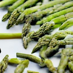 a baking pan with asparagus that has been drizzled with olive oil and sprinkled with salt.