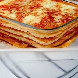 a pan of lasagna with six sheets of pasta, meatless mixture and ricotta cheese in the middle, and mozzarella and parmesan cheese on top.