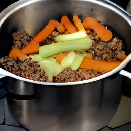 a pot of soup with onions, carrots, celery, garlic, vegetable broth and meatless burger patties.