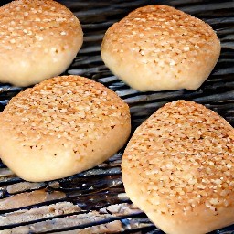 two whole grain buns that are cut in half and placed on a hot grill, cut side down. after grilling for two minutes, the heat is turned off.
