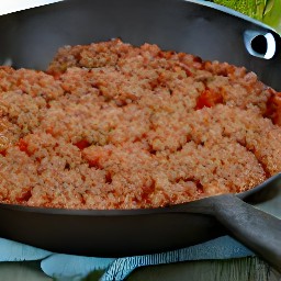the beyond beef cooked in a sauté pan with the garlic and tomato sauce. the cinnamon, oregano leaves, and salt added to the mixture. the coriander used as a garnish.