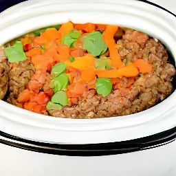 a crock-pot full of beyond beef and veggies in a tomato-based sauce.