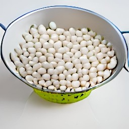 the white beans are rinsed in a colander.