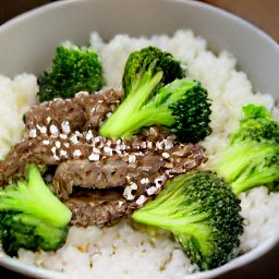 a bowl of white rice topped with beyond beef and steamed broccoli, garnished with green onions and sesame seeds.