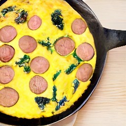 a dish containing beyond sausages, cooked onions, wilted spinach, and egg mixture, with grapeseed oil and shredded parmesan cheese on top.