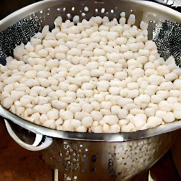 the white beans are rinsed in a colander.