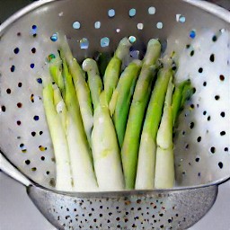 the asparagus is drained in a colander.