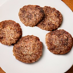 the beef sliders are transferred to a plate.