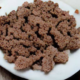 the crumbled burger patties are transferred to a plate.