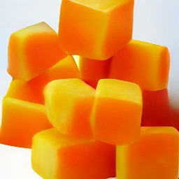 a peeled butternut squash that is cut in half and has the seeds removed, then it is chopped into cubes.