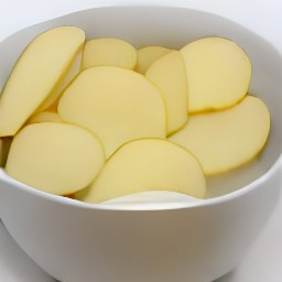 5 cups of water in a bowl with potato slices soaking.