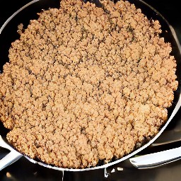 the meatless burger patties are crumbled with a wooden spoon.