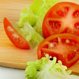 after peeling the onion, green onion, and garlic, chop them into small pieces. then slice the tomatoes and trim the lettuce leaves.