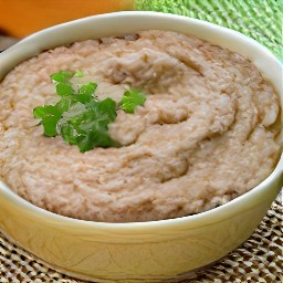 the refried beans are transferred to a microwavable bowl.