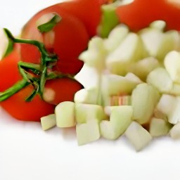 garlic that is peeled and minced, and tomatoes that are cut into quarters.