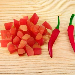 half and deseeded red chili peppers that are then diced.