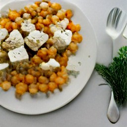 a platter with the content of the roasting tray, feta cheese crumbles, chopped fresh dill, and pickled radishes mixed together. it is then sprinkled with toasted pumpkin seeds, more