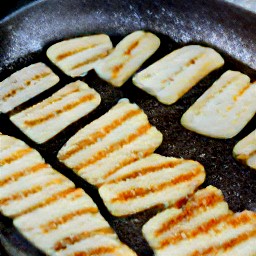 flipping the halloumi cheese slices with a spoon and cooking for another minute.