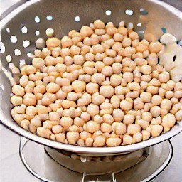 the canned chickpeas are drained in a colander.