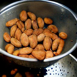 after rinsing the almonds in a colander and peeling the skin, the almonds are cut in halves.