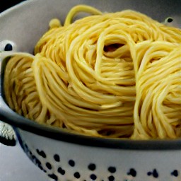 the cooked egg tagliolini are drained in a colander.