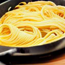 the egg tagliolini heated in a frying pan with the cooking water and lemon juice. the dish seasoned with salt and black pepper.