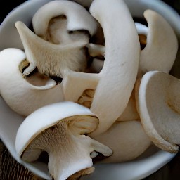 a bowl of white mushroom slices combined with half of the lemon juice.