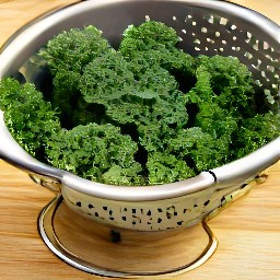 the kale is rinsed and drained in a colander.