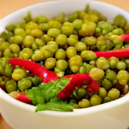 a bowl of peas with butter, shallots, garlic, red chili pepper slices, and spearmint.