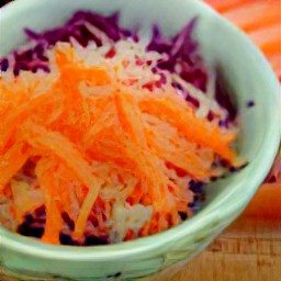 a salad made with sliced cabbage, sliced red cabbage, grated carrots, diced onions and dressing.