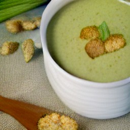 the celery soup is served topped with bread cubes in a serving bowl.