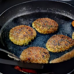 the semi cooked vegetarian bean burgers were flipped using a spatula.