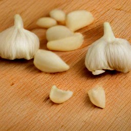 cherry tomatoes that are cut in half and peeled garlic.