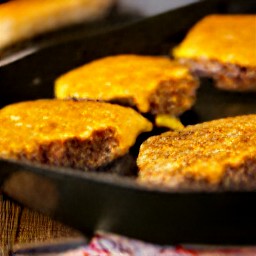 a burger with a slice of cheddar cheese on top, cooked for 2 minutes until the cheese is melted.