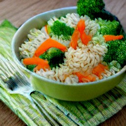 a bowl of stir-fry with olive oil, onions, carrots, red bell pepper strips, broccoli florets, basmati rice and eggs.
